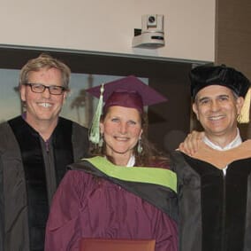 Graduation photo of Debra Emanuelle and two faculty members