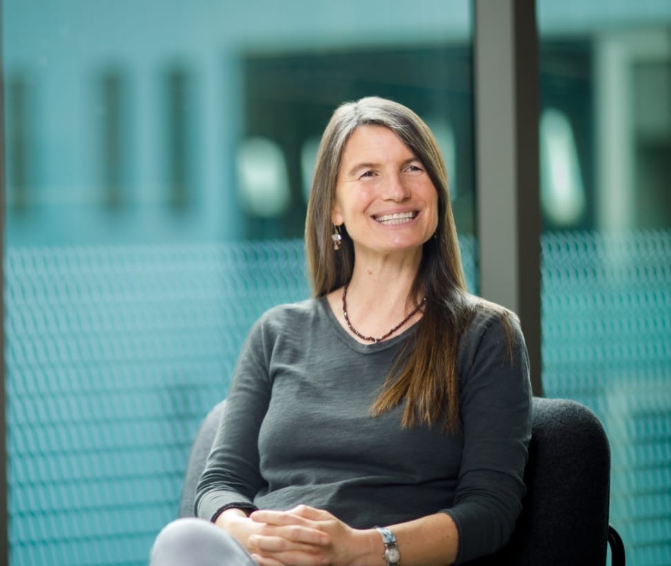 A person is smiling at another person while sitting on a chair