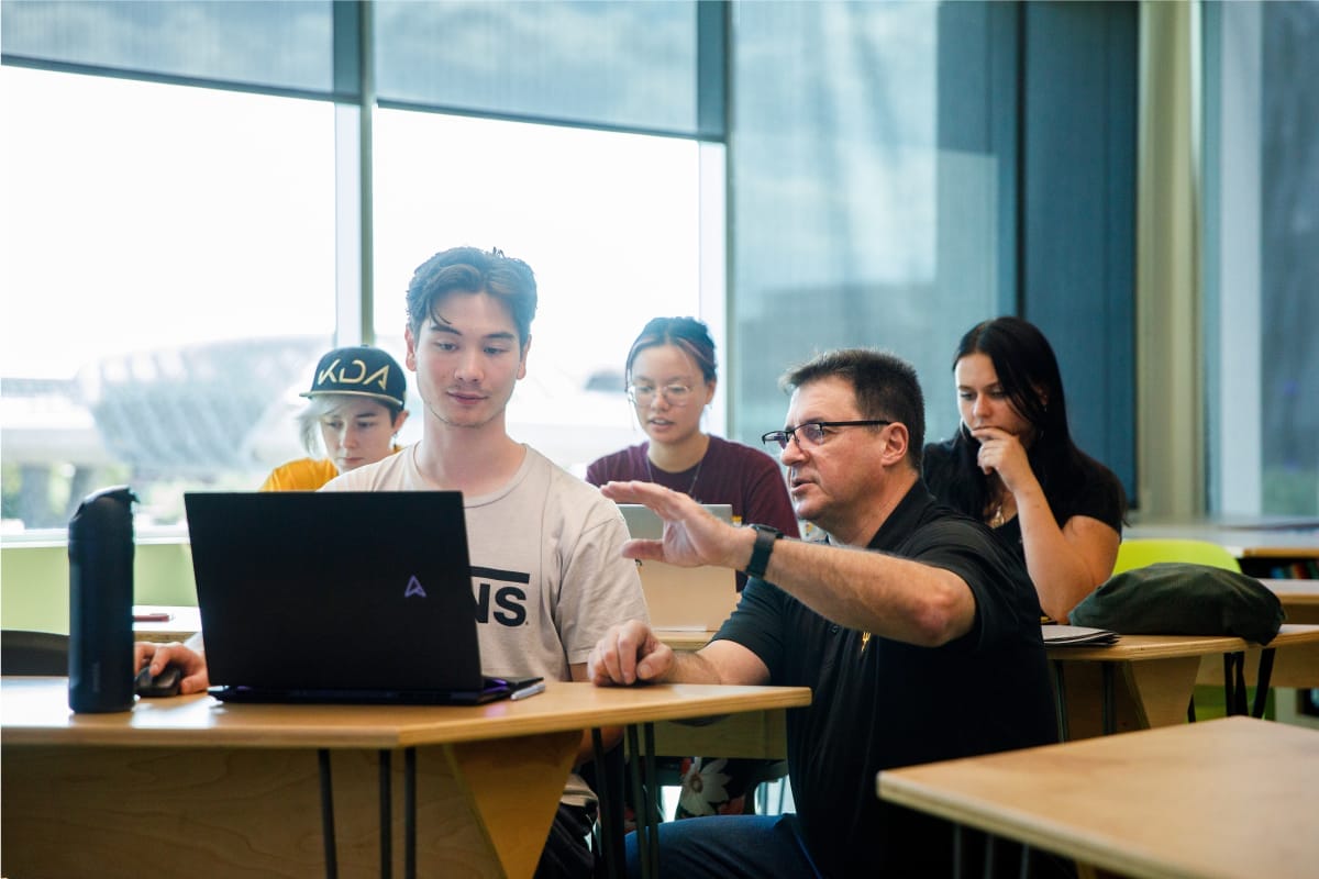 A group of people are studying and discussing while sitting in a classroom